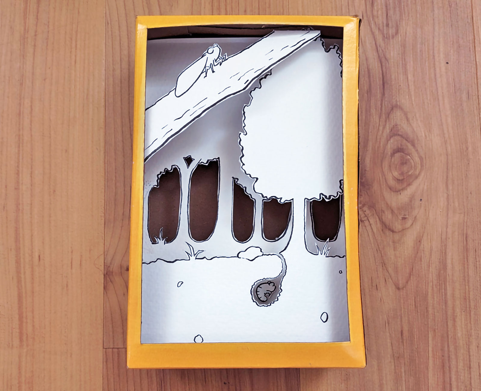 A 3-layer paper diorama in a Wheat Thins box