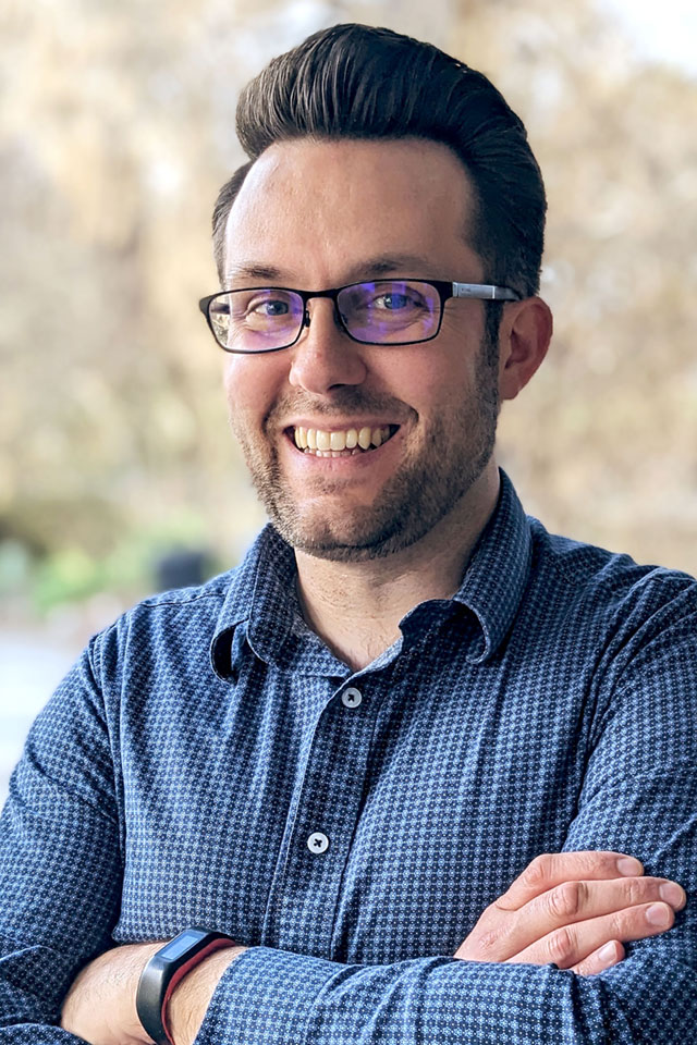 Photo of Roger McMullan smiling with arms crossed
